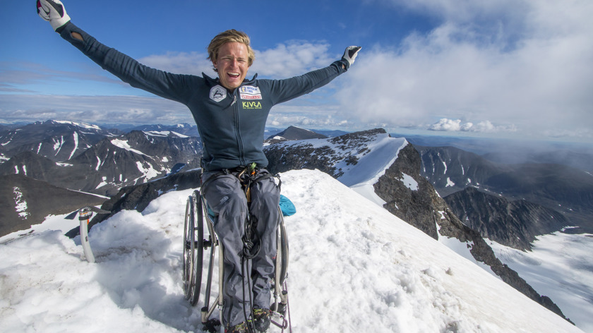 Fotografi av Aron Anderson, sittandes i rullstol på en bergstopp.